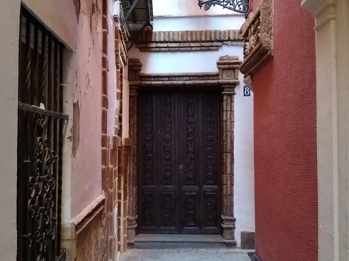 A whitewashed lane in the Barrio Santa Cruz of Seville, Spain